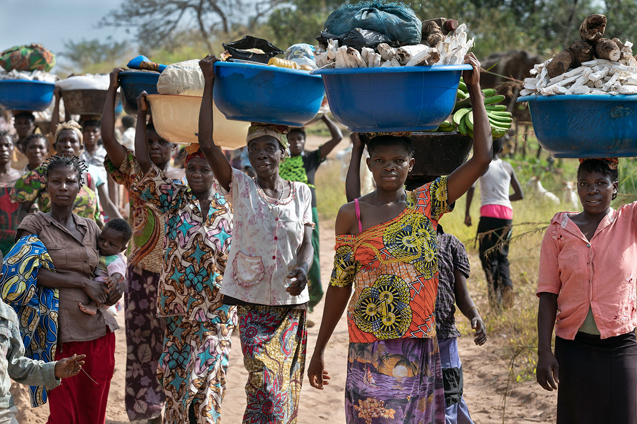 DR Kongo: Frauen tragen ihre Felderträge in Plastikschalen zum Markt des nächst grösseren Dorfes. Photo: Christoph Püschner/Diakonie Katastrophenhilfe